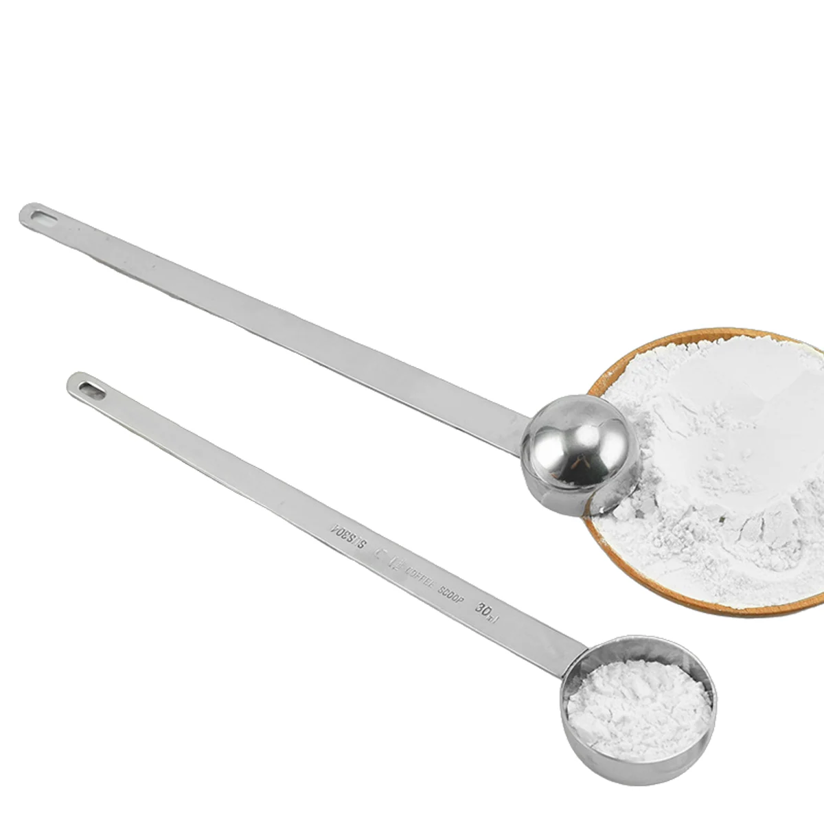 Long-handle steel scoops beside a bowl of white powder