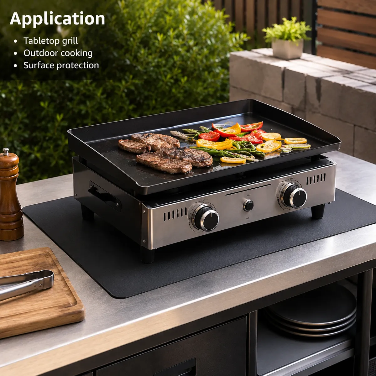 Black grill mat used under an outdoor tabletop griddle