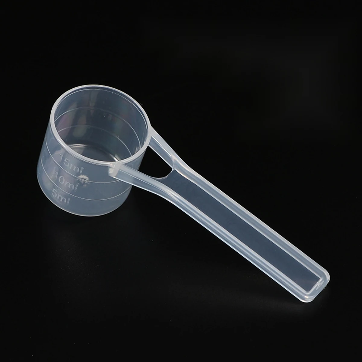 Close view of a translucent PP measuring scoop with molded millilitre graduation marks