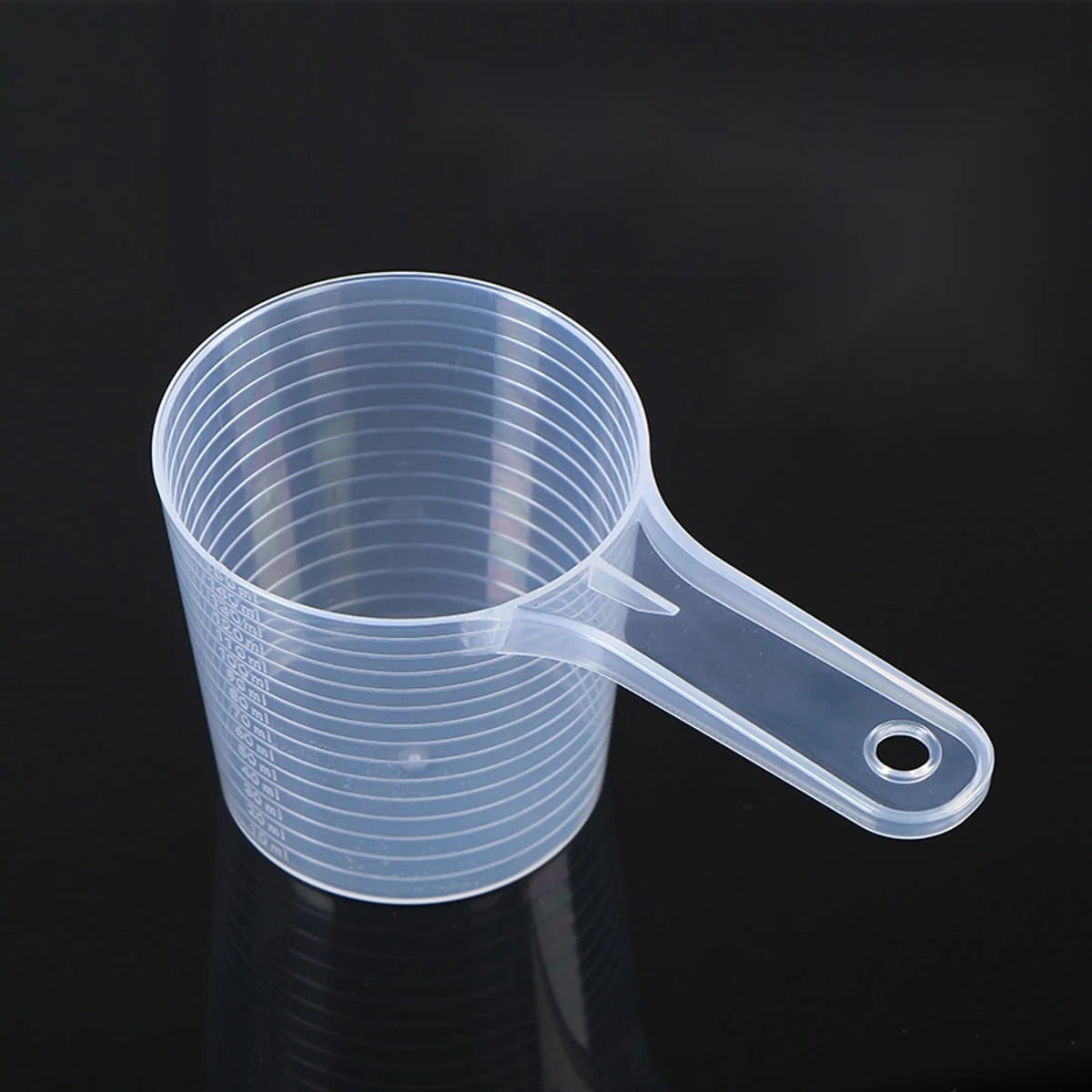 Large clear plastic measuring scoop with fine mL graduation lines and hanging hole